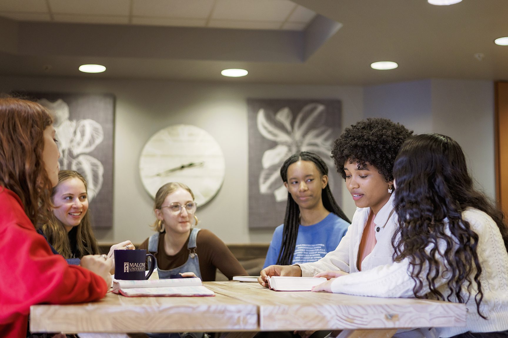 6 women of various ethnicities seated around a table