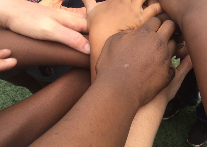 Group of hands of mixed races stacked on top of one another.
