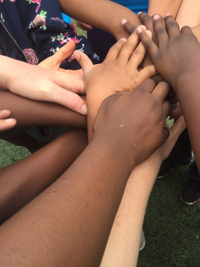 Group of hands of mixed races stacked on top of one another.
