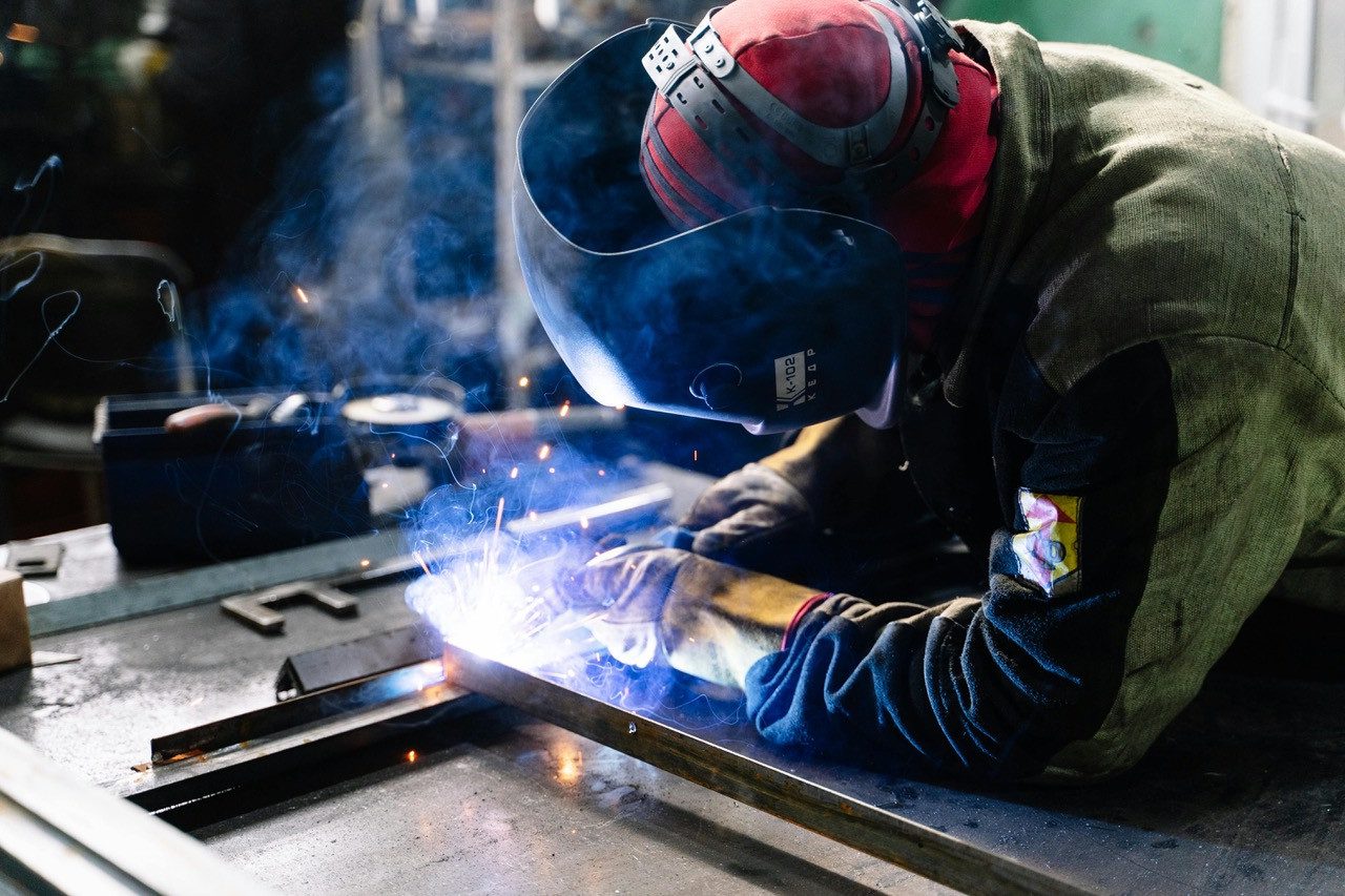 Welder welding two steel bars