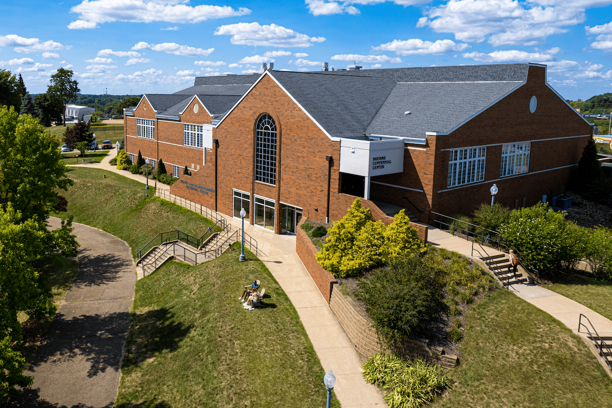 Exterior shot of a large brick building with white paned windows; the Centennial Center at Malone University