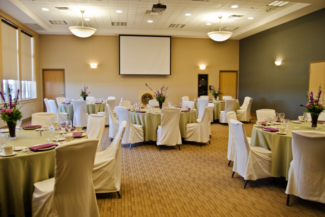 Room at Malone set up for a formal event with round tables and chairs