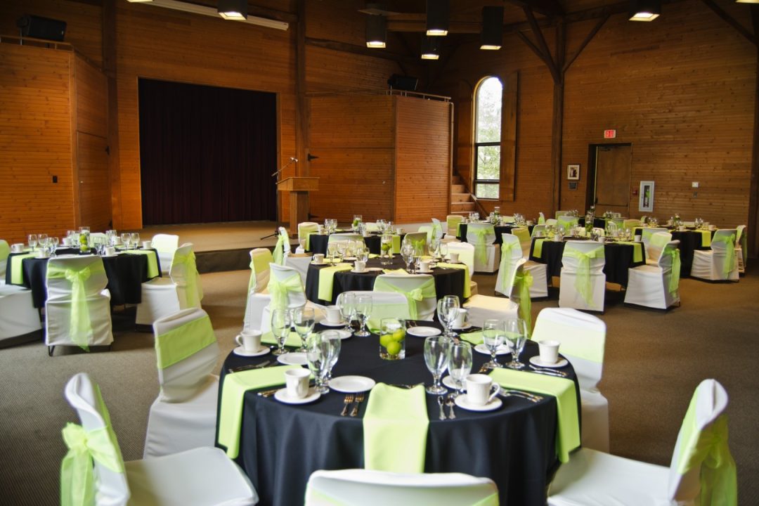 Large conference room set up with black tablecloths on round tables for a formal event