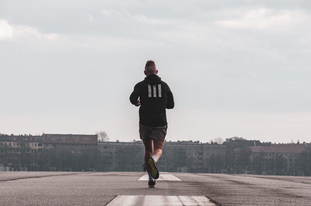 image of a man with his back turned to the camera while taking a jog