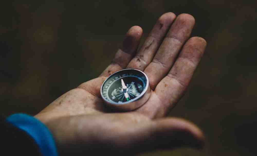 an image of someone holding a compass in the palm of their hand